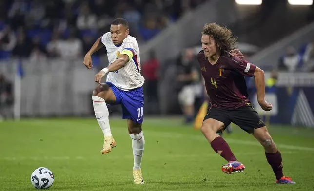 France's Kylian Mbappe, left, and Belgium's Wout Faes fight for the ball during the UEFA Nations League soccer match between France and Belgium at the Groupama stadium in Decines, outside Lyon, France, Monday, Sept. 9, 2024. (AP Photo/Laurent Cipriani)