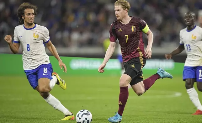 France's Matteo Guendouzi, left, runs to stop Belgium's Kevin De Bruyne during the UEFA Nations League soccer match between France and Belgium at the Groupama stadium in Decines, outside Lyon, France, Monday, Sept. 9, 2024. (AP Photo/Laurent Cipriani)