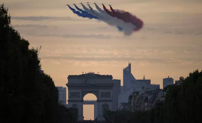 FILE - Alpha Jets from the Patrouille de France fly over the Champs-Elysees as delegations arrive for the Opening Ceremony for the 2024 Paralympics, Wednesday, Aug. 28, 2024, in Paris, France. (AP Photo/Aurelien Morissard, file)