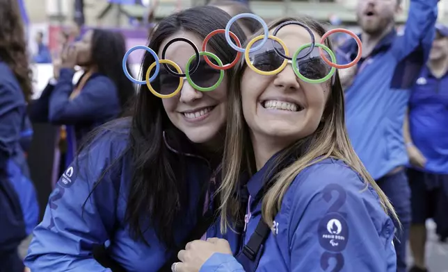 Volunteers of Paris 2024 Olympics and French athletes who participated in the 2024 Olympics and Paralympics take part in a parade in front of the Arc de Triomphe monument on the Champs Elysees, Saturday, Sept. 14, 2024 in Paris. (Andre Pain/Pool Photo via AP)