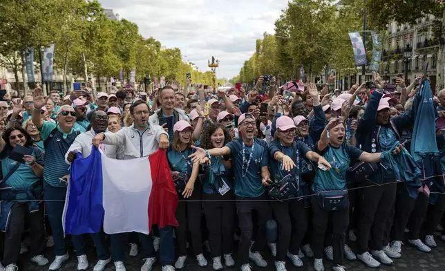 Volunteers of Paris 2024 Olympics march on the Champs Elysees with French athletes who participated in the 2024 Olympics and Paralympics, Saturday, Sept. 14, 2024 in Paris. Organizers have promised a celebration of French sport on par with the spectacular and audacious opening and closing of the July 26-Aug. 11 Olympics and the Aug. 28-Sept. 8 Paralympic ceremonies. (AP Photo/Aurelien Morissard, Pool)