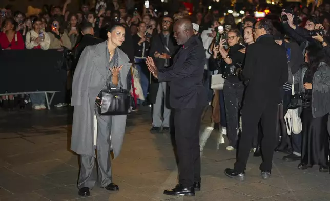 Adriana Lima, left, speaks with a security guard upon departure from the Schiaparelli Spring/Summer 2025 collection presented Thursday, Sept. 26, 2024, in Paris. (Photo by Scott A Garfitt/Invision/AP)