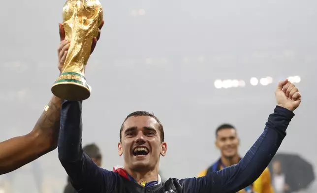 FILE - France's Antoine Griezmann, right with teammate France's Presnel Kimpembe hold the World Cup trophy as they celebrate after final match between France and Croatia at the 2018 soccer World Cup in the Luzhniki Stadium in Moscow, Russia, Sunday, July 15, 2018. (AP Photo/Francisco Seco, File)