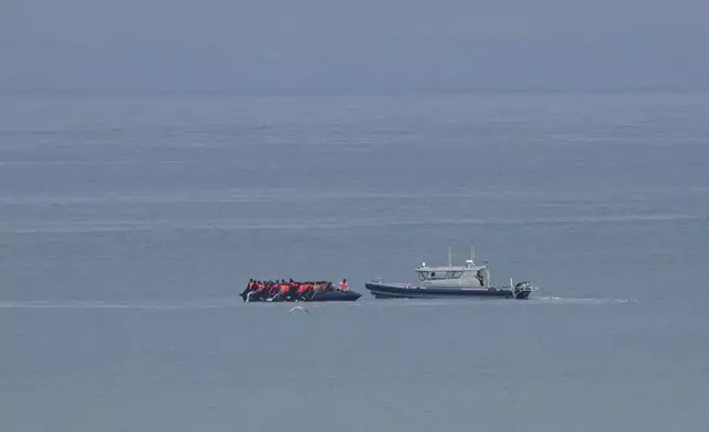 FILE - A boat thought to be with migrants is escorted by a vessel from the French Gendarmerie Nationale off the Wimereux beach, France, Sept. 4, 2024. (AP Photo/Nicholas Garriga, File)