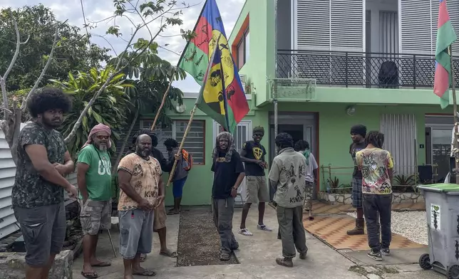 Indigenous Kanaks hold independent flags as they gather near the Field Action Coordination Unit building during the 171th anniversary of France's takeover of the Pacific Archipelago, in Noumea, New Caledonia, French Pacific islands, Tuesday Sept. 24, 2024. (AP Photo/Charlotte Antoine-Perron)