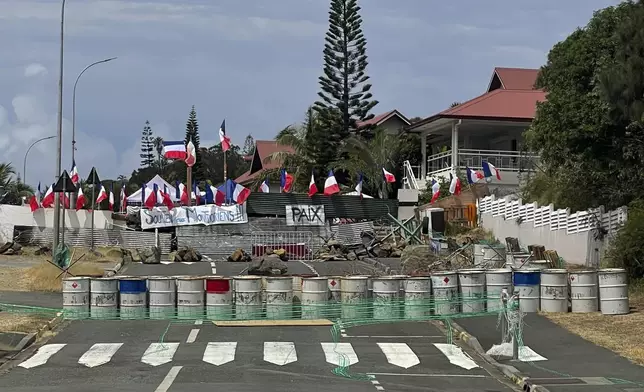 A pro-loyalist barricade with French flags is photographed during the anniv 171th anniversary of France's takeover of the Pacific Archipelago, in Noumea, New Caledonia, French Pacific islands, Tuesday Sept. 24, 2024. (AP Photo/Charlotte Antoine-Perron)