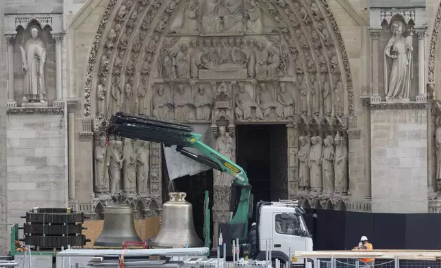 A truck carrying bells is parked outside Notre-Dame de Paris cathedral, in Paris, Thursday, Sept. 12, 2024. The Cathedral is getting its bells back, just in time for the medieval landmark's reopening following a devastating 2019 fire. (AP Photo/Michel Euler)