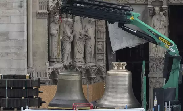 A truck carrying bells is parked outside Notre-Dame de Paris cathedral, in Paris, Thursday, Sept. 12, 204. A convoy of trucks bearing the restored bells pulled into the huge worksite surrounding the cathedral Thursday on an island in the Seine River. They will be blessed in a special ceremony inside the cathedral before being hoisted to hang in the monument's twin towers for the Dec. 8 reopening. (AP Photo/Michel Euler)