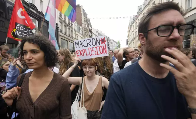 Demonstrators participate a protest, responding to a call from the far-left party who criticized as a power grab the president's appointment of a conservative new prime minister, Michel Barnier, in Paris, France, Saturday, Sept. 7, 2024. (AP Photo/Michel Euler)