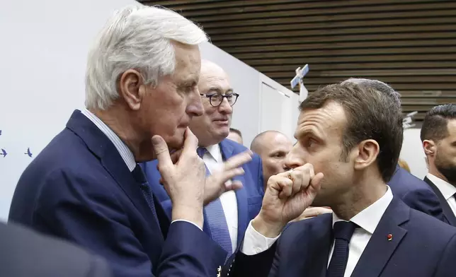 FILE - French President Emmanuel Macron, right, whispers to European Union chief Brexit negotiator Michel Barnier as he visits the International Agriculture Fair, in Paris, France. President Emmanuel Macron named the former EU Brexit negotiator as France's new prime minister on Thursday after more than 50 days of caretaker government. (AP Photo/Michel Euler, File)