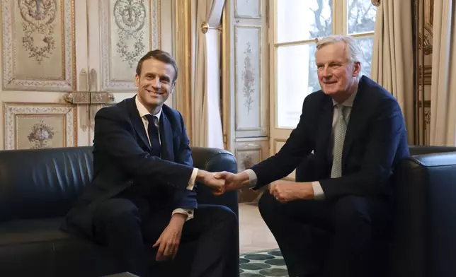 FILE - French President Emmanuel Macron, left, shakes hands with then-European Union chief Brexit negotiator Michel Barnier at the Elysee Palace in Paris, Friday, Jan. 31, 2020. (Ludovic Marin/Pool Photo via AP, File)