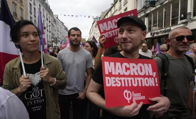 People, some carrying placards, participate in a protest demonstration responding to a call from the far-left party who criticized as a power grab the president's appointment of a conservative new prime minister, Michel Barnier, in Paris, France, Saturday, Sept. 7, 2024. (AP Photo/Michel Euler)