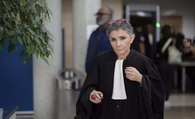 Lawyer Beatrice Zavarro walks during the trial of her client, defendant Dominique Pelicot, in the Avignon court house, southern France, Thursday, Sept. 5, 2024. A woman who was allegedly drugged by her now ex-husband so that she could be raped while unconscious by other men is testifying in a court in France about her yearslong ordeal. (AP Photo/Lewis Joly)