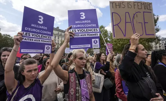 People take part in a gathering in support of 71-year-old Gisele Pelicot who was allegedly drugged by her ex-husband and raped by dozens of men while unconscious, Saturday, Sept. 14, 2024 in Paris. Placards left read, "3 billion euros to combat violence against women." (AP Photo/Michel Euler)