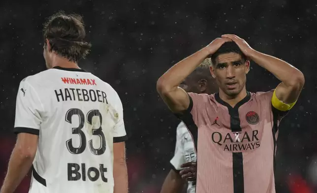 PSG's Achraf Hakimi, right, reacts after missing a chance to score during the French League One soccer match between Paris Saint-Germain and Rennes at the Parc des Princes in Paris, Friday, Sept. 27, 2024. (AP Photo/Thibault Camus)