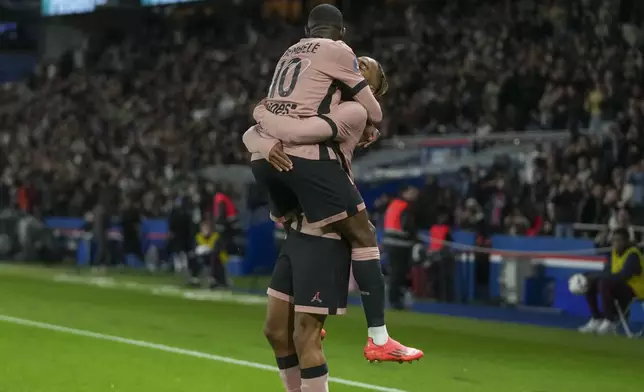 PSG's Bradley Barcola, right, celebrates with PSG's Ousmane Dembele after scoring his side's opening goal during the French League One soccer match between Paris Saint-Germain and Rennes at the Parc des Princes in Paris, Friday, Sept. 27, 2024. (AP Photo/Thibault Camus)