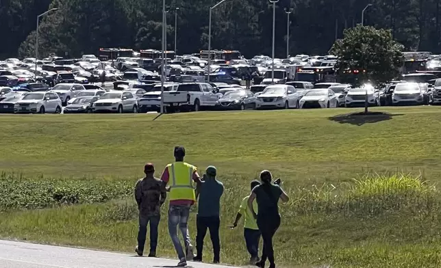 Students are evacuated to the football stadium after the school campus was placed on lockdown at Apalachee High School in Winder, Ga., on Wednesday, Sept. 4, 2024. (Erin Clark via AP)