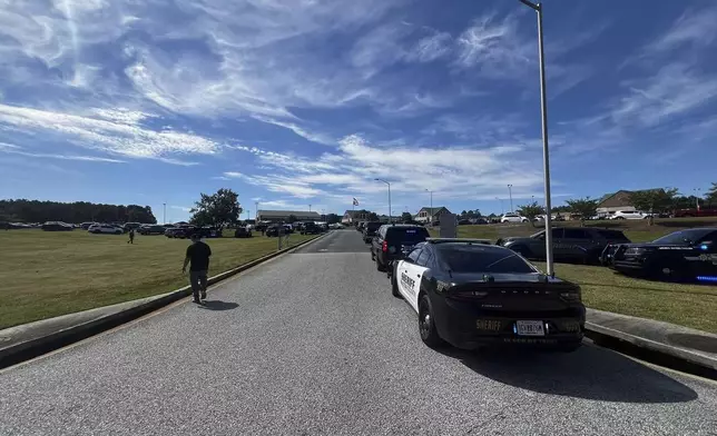 Law enforcement arrive as students are evacuated to the football stadium after the school campus was placed on lockdown at Apalachee High School in Winder, Ga., on Wednesday, Sept. 4, 2024. (Erin Clark via AP)