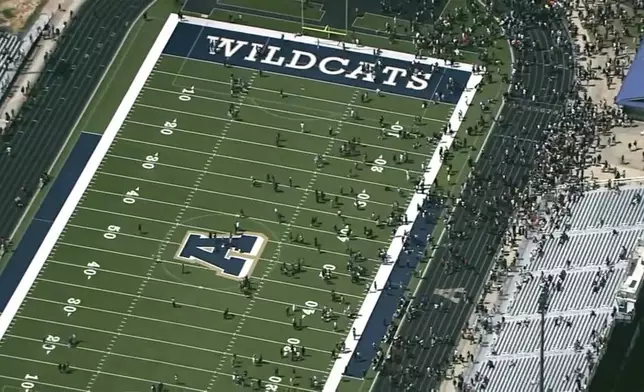 Students are evacuated to the football stadium after the school campus was placed on lockdown at Apalachee High School in Winder, Ga., on Wednesday, Sept. 4, 2024. (WSB via AP)