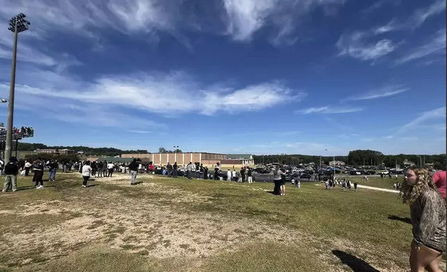 Students are evacuated to the football stadium after the school campus was placed on lockdown at Apalachee High School in Winder, Ga., on Wednesday, Sept. 4, 2024. (Erin Clark via AP)