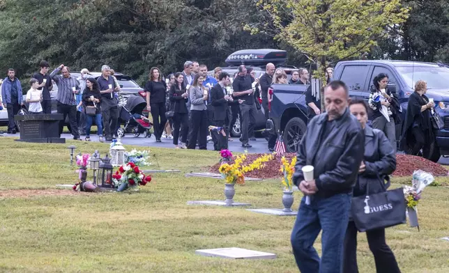 Mourners follow the casket of Ana Cristina Irimie, a math teacher killed during a shooting at Apalachee High School, to the burial site after her funeral service at Hamilton Mill Memorial Chapel and Gardens in Buford, Ga., on Saturday, Sept. 14, 2024. (Arvin Temkar/Atlanta Journal-Constitution via AP)