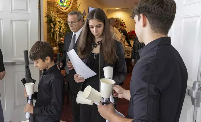 Mourners grieve for Ana Cristina Irimie, a math teacher killed during a shooting at Apalachee High School, during her funeral service at Hamilton Mill Memorial Chapel and Gardens in Buford, Ga., on Saturday, Sept. 14, 2024. (Arvin Temkar/Atlanta Journal-Constitution via AP)