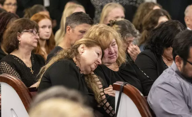 Mourners grieve for Ana Cristina Irimie, a math teacher killed during a shooting at Apalachee High School, during her funeral service at Hamilton Mill Memorial Chapel and Gardens in Buford, Ga., on Saturday, Sept. 14, 2024. (Arvin Temkar/Atlanta Journal-Constitution via AP)