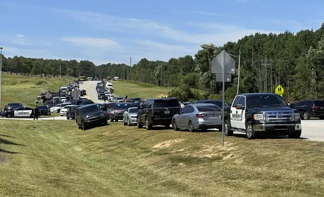 Law enforcement arrive as students are evacuated to the football stadium after the school campus was placed on lockdown at Apalachee High School in Winder, Ga., on Wednesday, Sept. 4, 2024. (AP Photo/Jeff Amy)