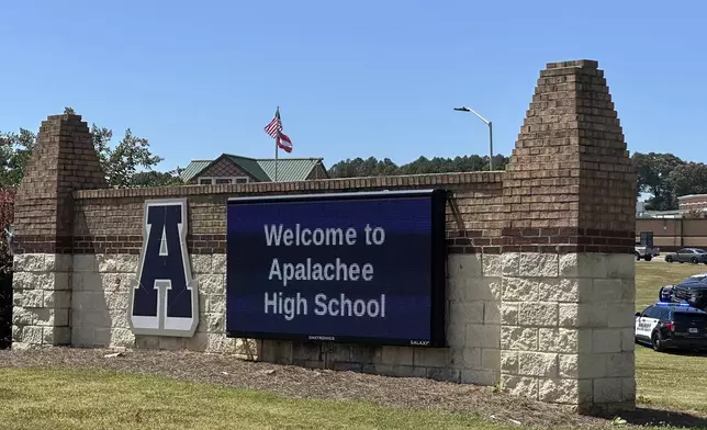 Law enforcement arrive as students are evacuated to the football stadium after the school campus was placed on lockdown at Apalachee High School in Winder, Ga., on Wednesday, Sept. 4, 2024. (AP Photo/Jeff Amy)