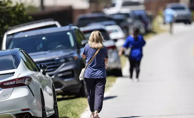 Parents walk to Apalachee High School after a shooting at the school Wednesday, Sept. 4, 2024, in Winder, Ga. (AP Photo/Mike Stewart)