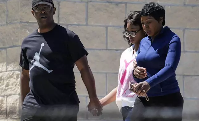 Parents walk their child out of Apalachee High School after a shooting at the school, Wednesday, Sept. 4, 2024, in Winder, Ga. (AP Photo/Mike Stewart