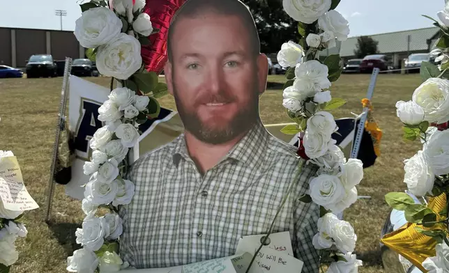 A poster with an image of shooting victim Richard Aspinwall is displayed at a memorial outside Apalachee High School, Tuesday, Sept. 10, 2024, in Winder, Ga. (AP Photo/Charlotte Kramon)