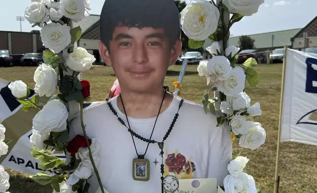 A poster with an image of shooting victim Christian Angulo is displayed at a memorial outside Apalachee High School, Tuesday, Sept. 10, 2024, in Winder, Ga. (AP Photo/Charlotte Kramon)