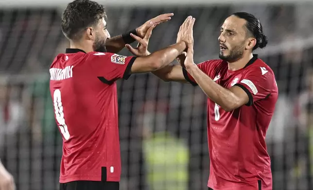 Georgia's Zuriko Davitashvili, left, and Giorgi Kochorashvili celebrate their 4-1 victory in the UEFA Nations League soccer match between Georgia and Czech Republic at the Mikheil Meskhi stadium in Tbilisi, Georgia, Saturday, Sept. 7, 2024. (AP Photo/Tamuna Kulumbegashvili)