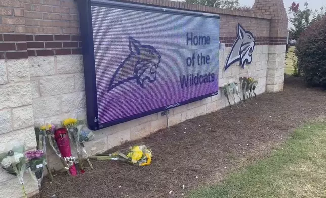 Flowers are placed outside the entrance to Apalachee High School on Thursday, Sept. 5, 2024 in Winder, Ga., a day after deadly shootings at the school. (AP Photo/Sharon Johnson)