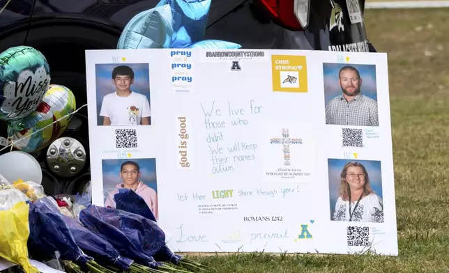 A poster with images of victims Christian Angulo, top left, Richard Aspinwall, top right, Mason Schermerhorn, bottom left, and Cristina Irimie is displayed at a memorial outside Apalachee High School, Friday, Sept. 6, 2024, in Winder, Ga., following a shooting at the school earlier in the week. (Arvin Temkar/Atlanta Journal-Constitution via AP)