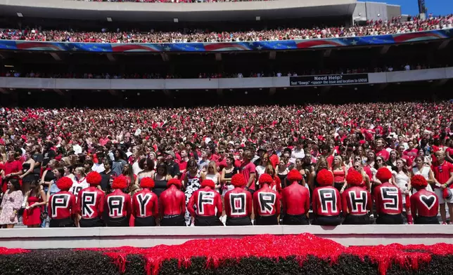 Fans observe a moment of silence for victims of Wednesday's school shooting at Apalachee High School before an NCAA college football game between Tennessee Tech and Georgia Saturday, Sept. 7, 2024, in Athens, Ga. (AP Photo/John Bazemore)