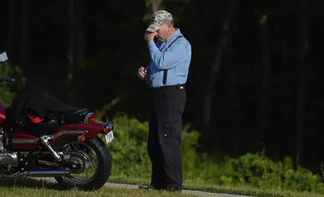 A mourner wipes tears from their face for the slain students and teachers at Apalachee High School, on Thursday, Sept. 5, 2024, in Winder, Ga. (AP Photo/Brynn Anderson)