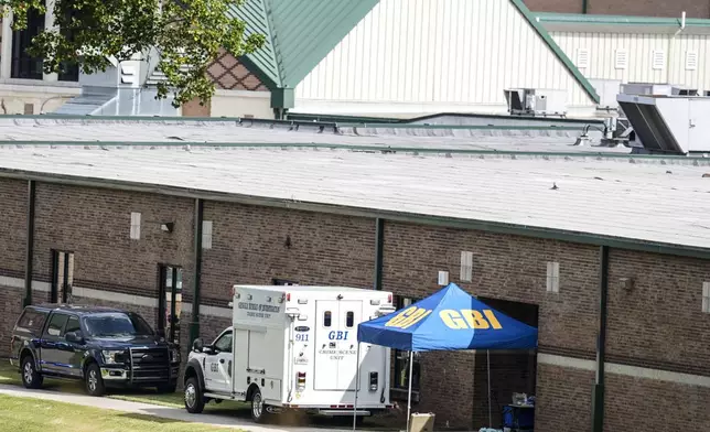 Georgia Bureau of Investigation staff move through an entrance to Apalachee High School after Wednesday's multiple shooting, Thursday, Sept. 5, 2024, in Winder, Ga. (AP Photo/Mike Stewart)WLD