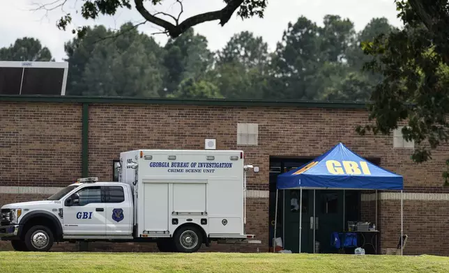 Georgia Bureau of Investigation staff move through an entrance to Apalachee High School after Wednesday's shooting, Thursday, Sept. 5, 2024, in Winder, Ga. (AP Photo/Mike Stewart)