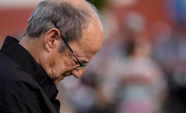 Dan Williamson prays during a candlelight vigil for the slain students and teachers at Apalachee High School, Wednesday, Sept. 4, 2024, in Winder, Ga. (AP Photo/Mike Stewart)