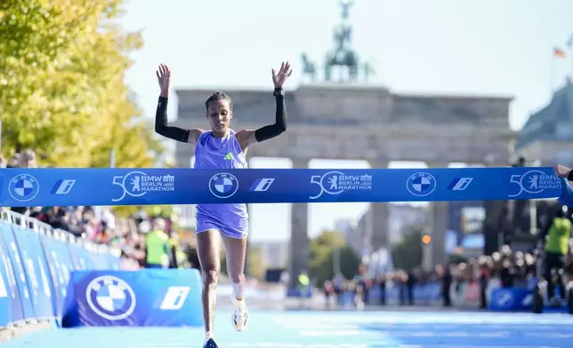 Tigist Ketema from Ethiopia celebrates as he crosses the finish line to win the women's division of the Berlin Marathon in Berlin, Germany, Sunday, Sept. 29, 2024. (AP Photo/Ebrahim Noroozi)