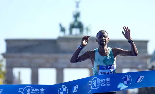 Milkesa Mengesha from Ethiopia celebrates as he crosses the finish line to win the men's division of the Berlin Marathon in Berlin, Germany, Sunday, Sept. 29, 2024. (AP Photo/Ebrahim Noroozi)