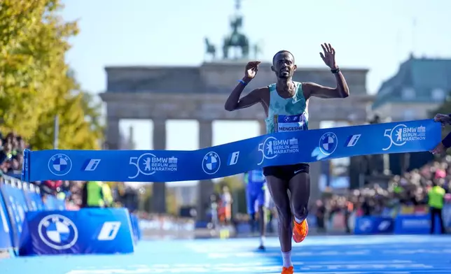 Milkesa Mengesha from Ethiopia celebrates as he crosses the finish line to win the men's division of the Berlin Marathon in Berlin, Germany, Sunday, Sept. 29, 2024. (AP Photo/Ebrahim Noroozi)