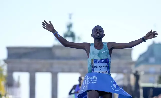 Milkesa Mengesha from Ethiopia celebrates as he crosses the finish line to win the men's division of the Berlin Marathon in Berlin, Germany, Sunday, Sept. 29, 2024. (AP Photo/Ebrahim Noroozi)