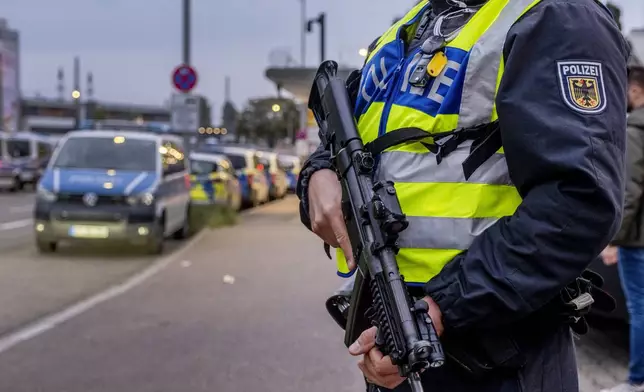 A German police officer holds a machine gun at the border between Germany and France in Kehl, Germany, Monday, Sept. 16, 2024 as Germany controls all his borders from Monday on. (AP Photo/Michael Probst)