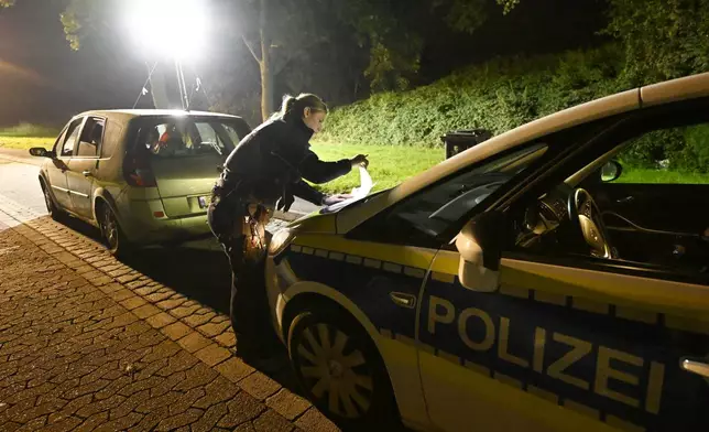 A police officer checks vehicles near the border with Belgium in Aachen, Germany, Monday, Sept. 16, 2024 Roberto Pfeil/dpa via AP)