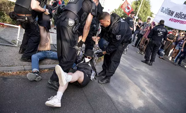 Police officers detain men during a protest against an election party of AfD supporters for the state elections in Saxony and Thuringia, in Berlin, Germany, Sunday, Sept. 1, 2024. (Fabian Sommer/dpa via AP)