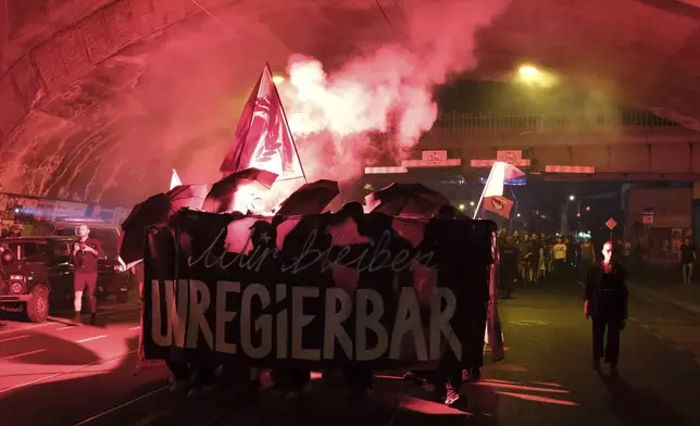 Protesters light pyrotechnics during a rally against the growth of right-wing parties in the state elections for Saxony, in Dresden, Germany, Sunday, Sept. 1, 2024. (Sebastian Willnow/dpa via AP)