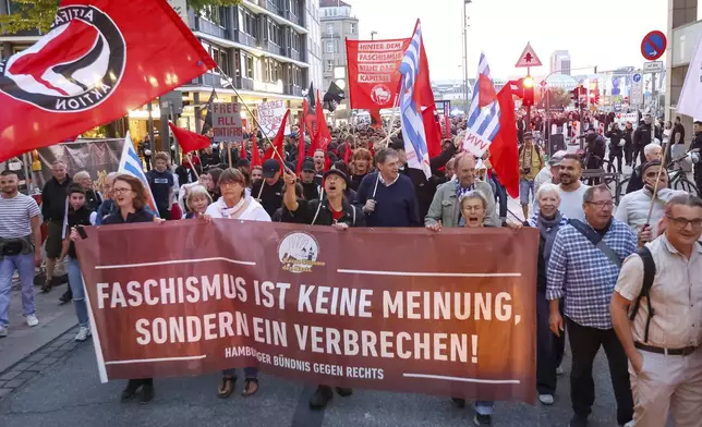 Participants in a demonstration against the right hold a banner reading "Fascism is not an opinion, it's a crime!" in Hamburg, Sunday, Sept. 1, 2024. (Bodo Marks/dpa via AP)